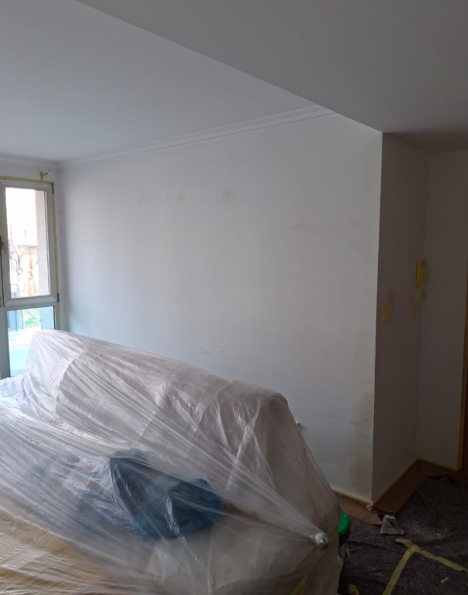 Wall area before repaint showing irregular marks and previous patch points.