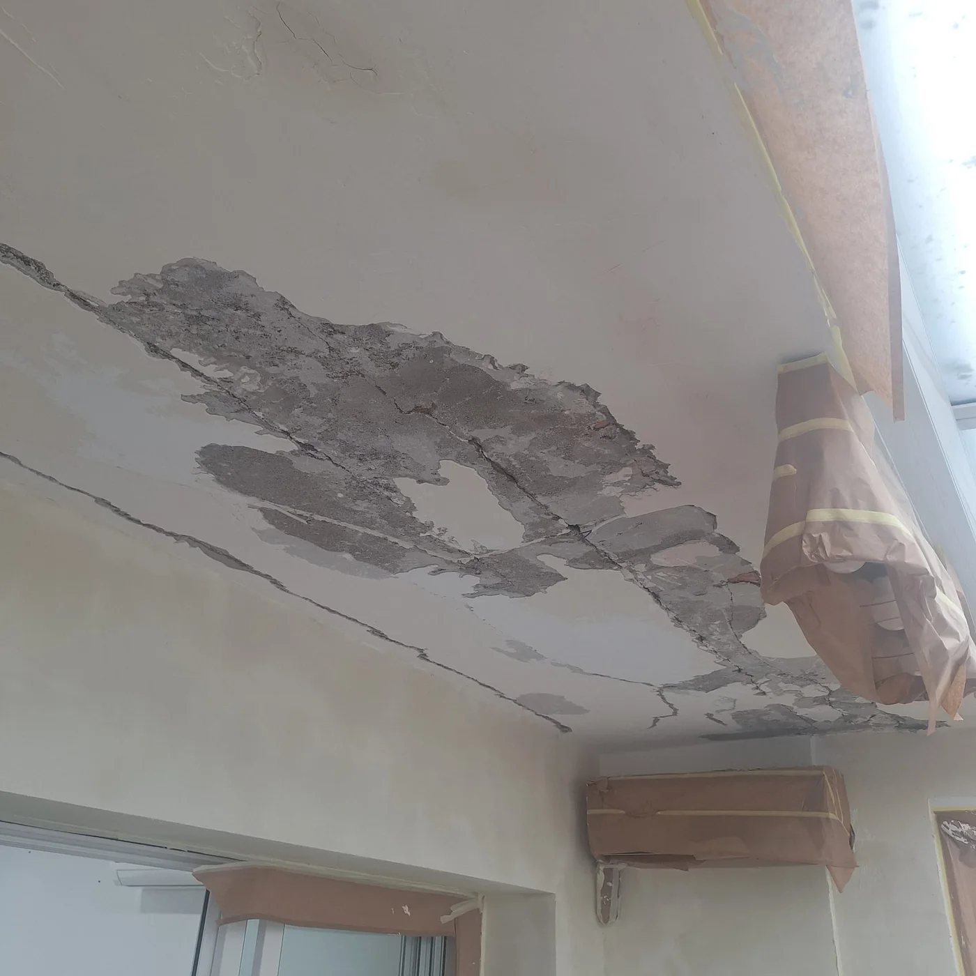 Initial ceiling condition with humidity damage and detached areas.