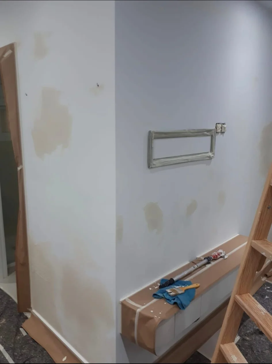 Interior wall in repair phase with patched and protected zones.